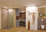 Modern bathroom with open shower, wooden floor, and natural decor highlighting stylish room lighting