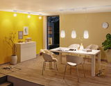 Moderne eetkamer met witte stoelen, houten vloer en drie witte hanglampen aan het plafond.