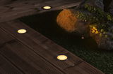 Drie verzonken LED-vloerlampen met warm wit licht op donker houten terras in tuin