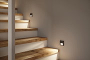 Moderne Treppenbeleuchtung mit quadratischen LED-Wandleuchten in Schwarz für Holzstufen.