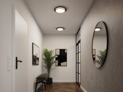 Moderner Flur mit runder Wandspiegel und zwei Deckenleuchten in Schwarz und Weiß, Holzfußboden