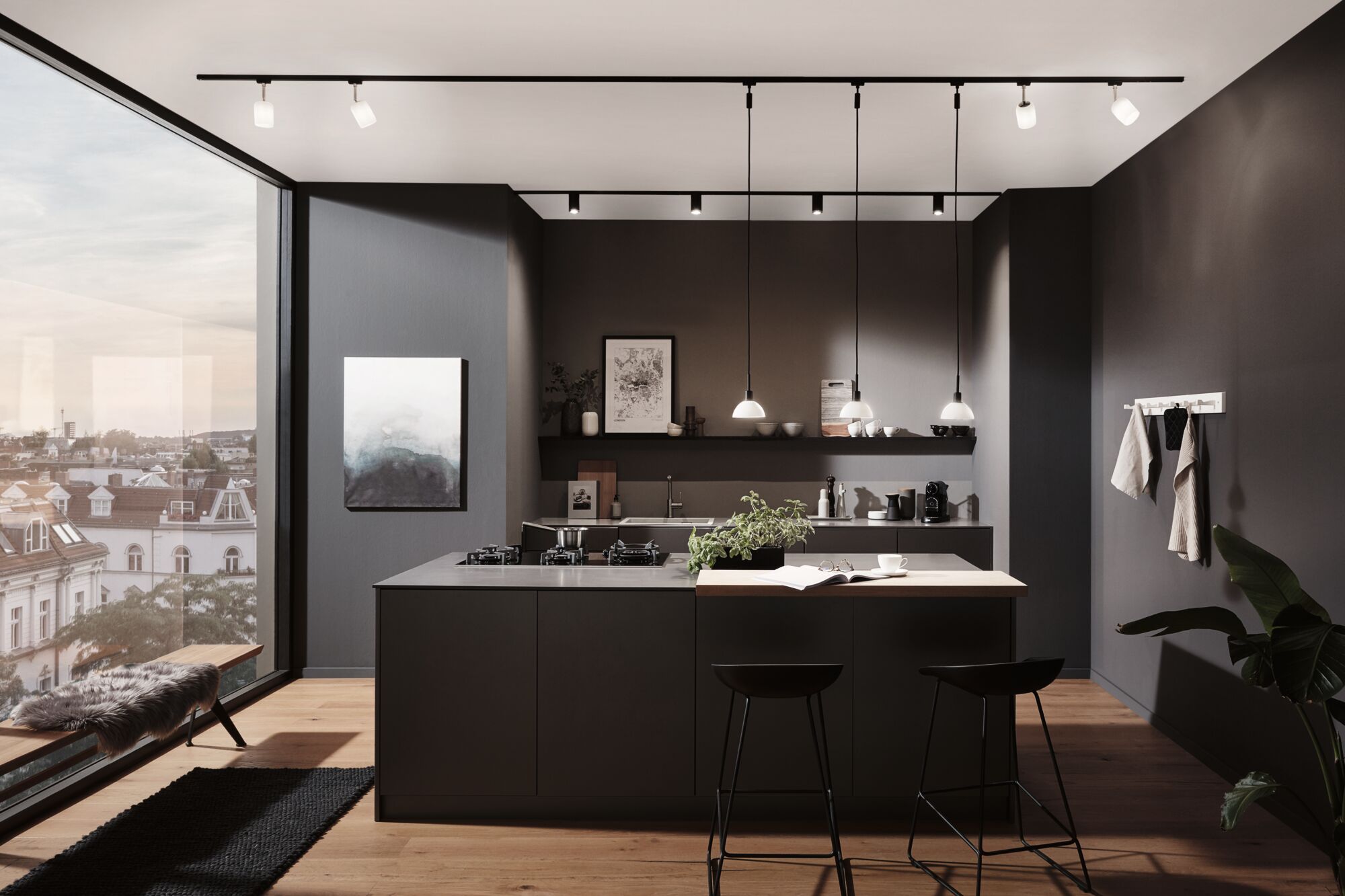 Cuisine moderne avec îlot noir, plan de travail en bois et suspensions LED minimalistes.