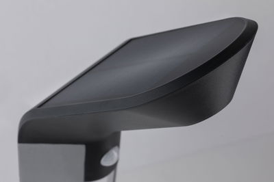 Schwarze Kunststoff-Außenleuchte mit modernem Design und Bewegungsmelder für Gartenbeleuchtung.