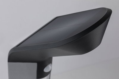 Schwarze Kunststoff-Außenleuchte mit modernem Design und Bewegungsmelder für Gartenbeleuchtung.