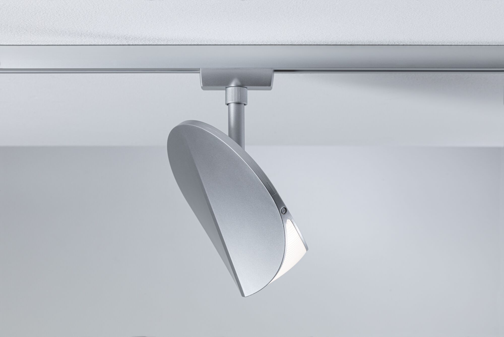 Moderner silberner LED-Strahler aus Metall an Schienensystem für flexible Raumbeleuchtung
