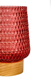 Red textured glass on light wooden base, decorative indoor lighting accent
