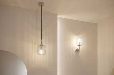 Modern pendant and wall light with clear glass and silver metal for ambient lighting in living spaces
