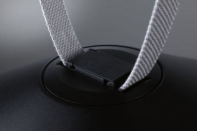 Gros plan sur clip en plastique noir avec sangle en tissu gris pour accessoire d'éclairage.