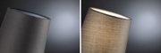 Close-up of grey fabric lampshade, left unlit, right glowing warmly, modern home lighting accessory