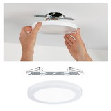 Round white LED ceiling light made of plastic with mounting bracket and ceiling installation