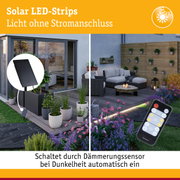 Solar LED-Strips mit schwarzem Solarpanel und Fernbedienung im modernen Garten mit Lounge-Möbeln