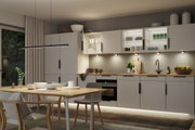 Moderne Küche mit grauen Schränken, Holzarbeitsplatte und LED-Unterbauleuchten für stimmungsvolle Beleuchtung