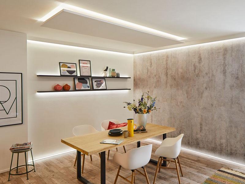 Modernes Esszimmer mit LED-Decken- und Wandbeleuchtung, Holztisch und weißen Stühlen, stilvolle Raumbeleuchtung.