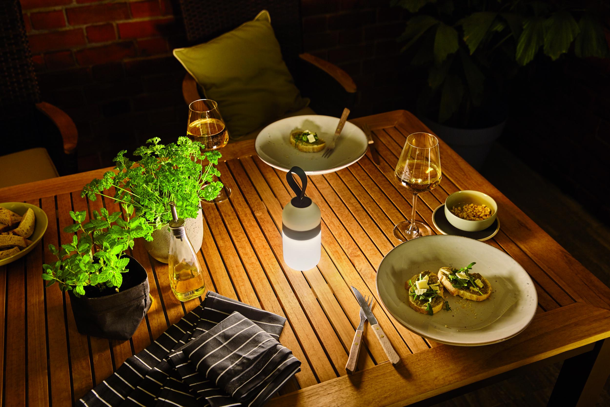 Bærbar LED-bordlampe med silikonehåndtag på træbord med snacks og vin udendørs