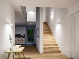Moderner Flur mit Holztreppe und weißen Wandleuchten für stilvolle Innenraumbeleuchtung