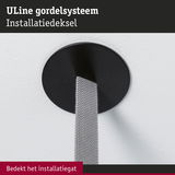 Zwarte ronde metalen installatiedeksel bedekt kabeldoorvoer in witte muur voor nette afwerking