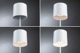 Vier witte metalen vloerlampen met cilindervormige kap tegen grijze achtergrond, verschillende lichtsterktes
