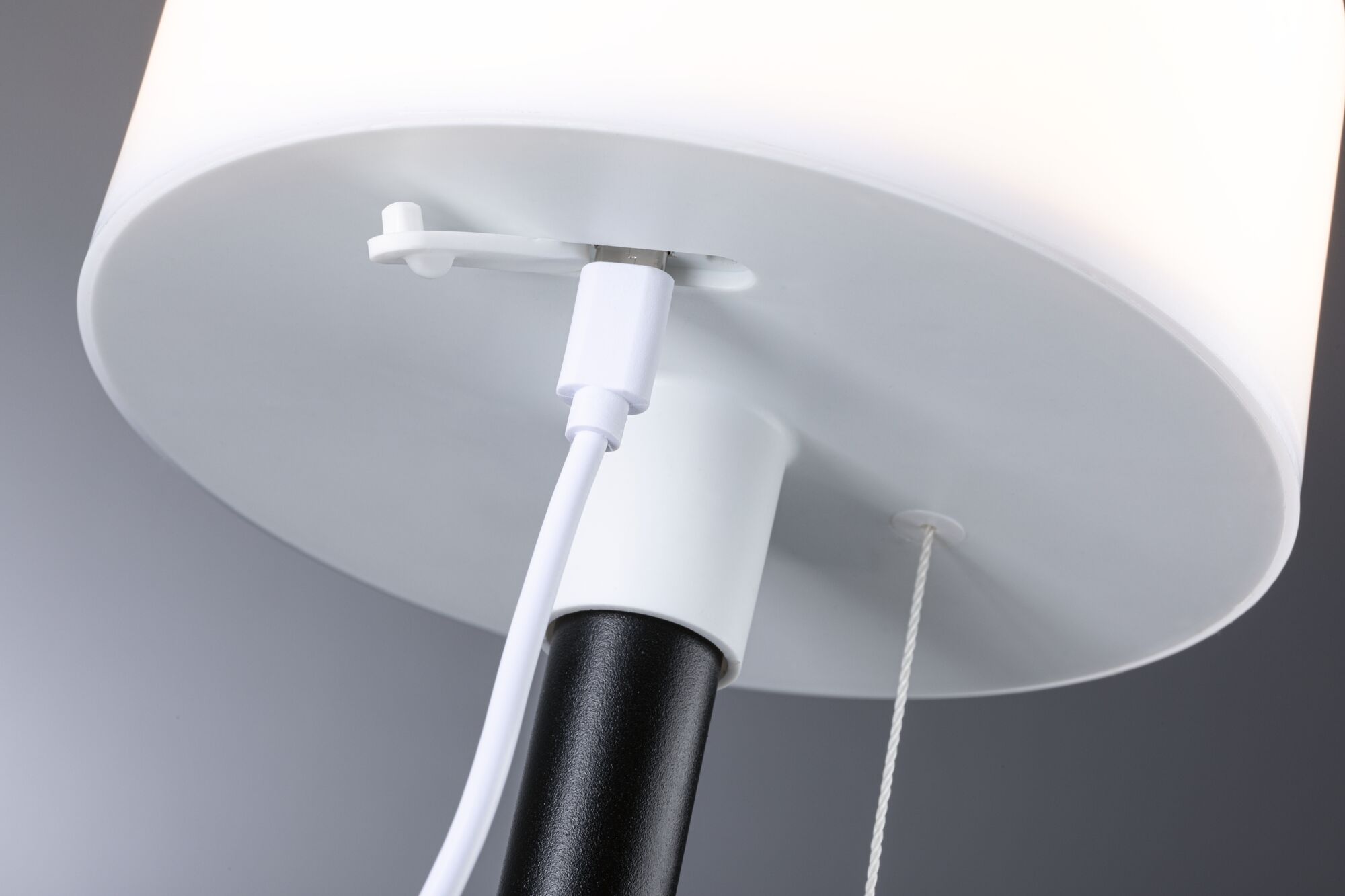 Gros plan sur un abat-jour blanc avec pied noir et câble USB blanc pour lampe LED