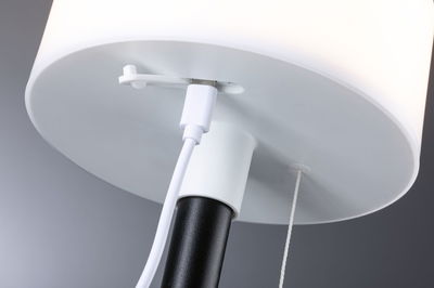 Gros plan sur un abat-jour blanc avec pied noir et câble USB blanc pour lampe LED