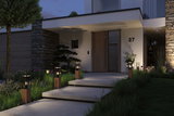 Modern outdoor pathway lights with wooden base and glass cover illuminating entrance at night