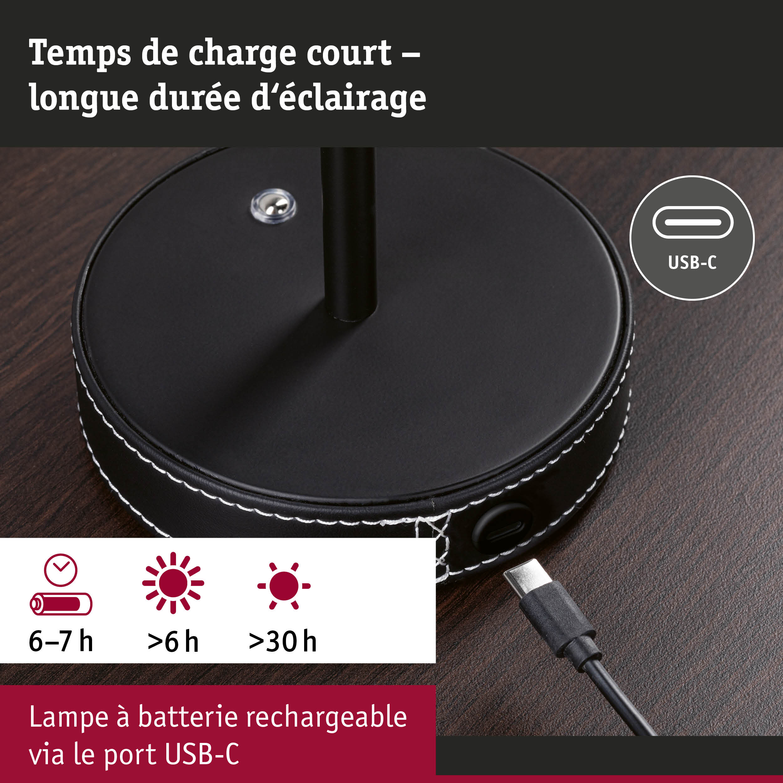 Lampe ronde noire à batterie rechargeable avec port USB-C et couture blanche sur table en bois