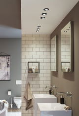 Modern bathroom with white ceramic sinks, wall-mounted faucets, and black LED recessed spotlights.