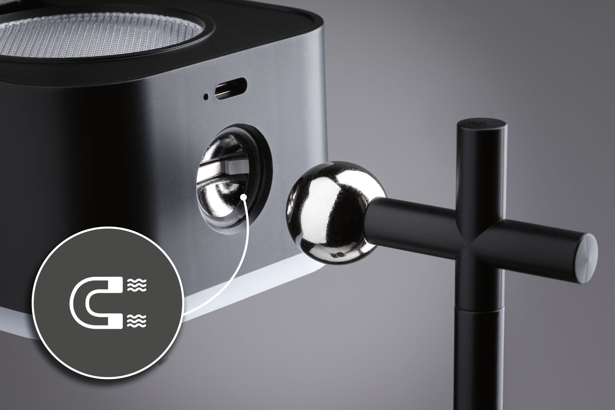 Black metal light with magnetic joint and shiny ball for adjustable lighting solutions.