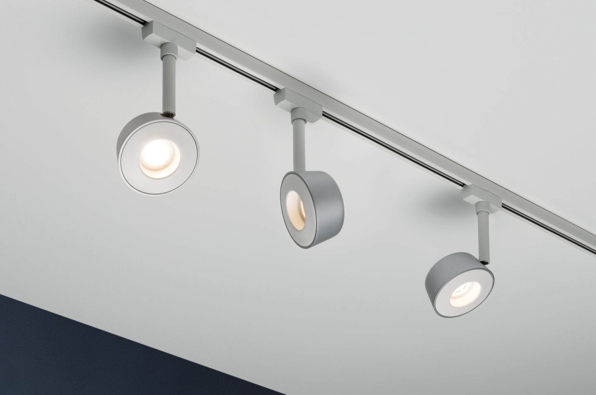 Drei moderne LED-Deckenspots in Grau an Schienensystem für flexible Raumbeleuchtung