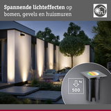 Moderne buitenverlichting met spannende lichteffecten op gevels en bomen in de tuin bij schemering