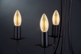 Drei schwarze Metallkerzenhalter mit warmweiß leuchtenden LED-Kerzenlampen für dekorative Beleuchtung