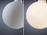 Image divisée d'un plafonnier globe en verre blanc, éteint à gauche, allumé à droite