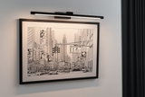Black metal LED picture light illuminating urban black and white cityscape with cars and skyscrapers.