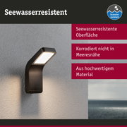 Schwarze Außenwandleuchte mit seewasserresistenter Oberfläche an grauer Wand mit Meerblick