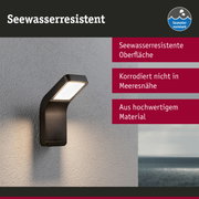 Schwarze Außenwandleuchte mit seewasserresistenter Oberfläche an grauer Wand mit Meerblick