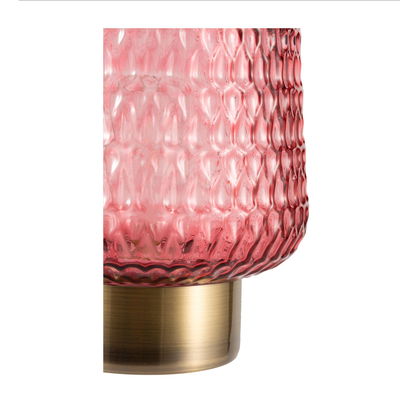 Close-up of red textured glass lampshade with brass-colored metal base for ambient lighting