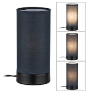 Cylindrical table lamp with black fabric shade and metal base for ambient lighting in interiors
