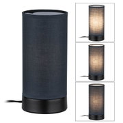Cylindrical table lamp with black fabric shade and metal base for ambient lighting in interiors