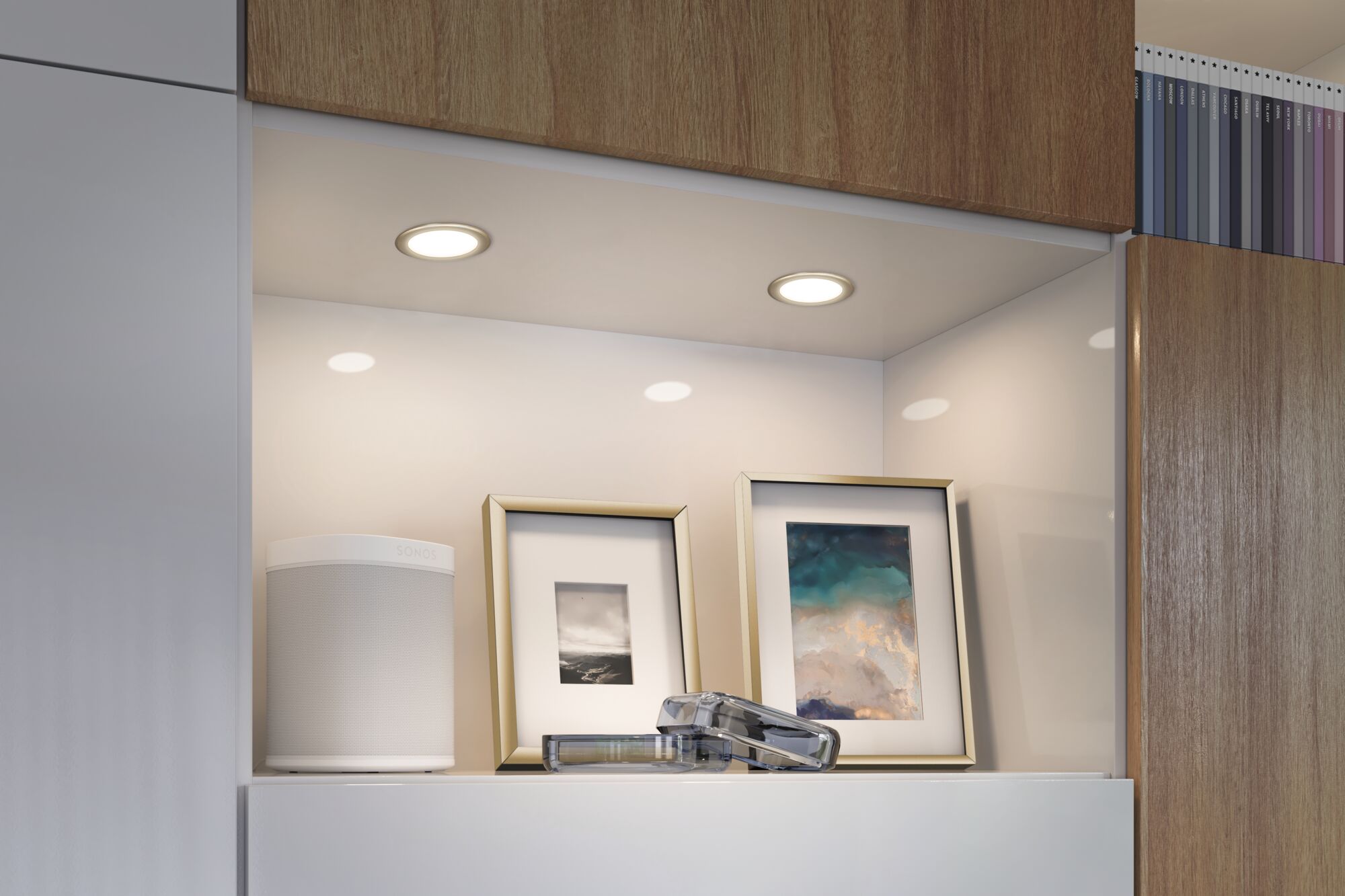 White LED recessed lights in modern wood and white kitchen with decor and speaker.