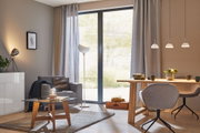 Modern living room with grey fabric armchair, wooden table, glass top and stylish LED pendant lights