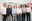 Six men in business attire standing in front of wall with pictures, formal farewell scene in office setting.