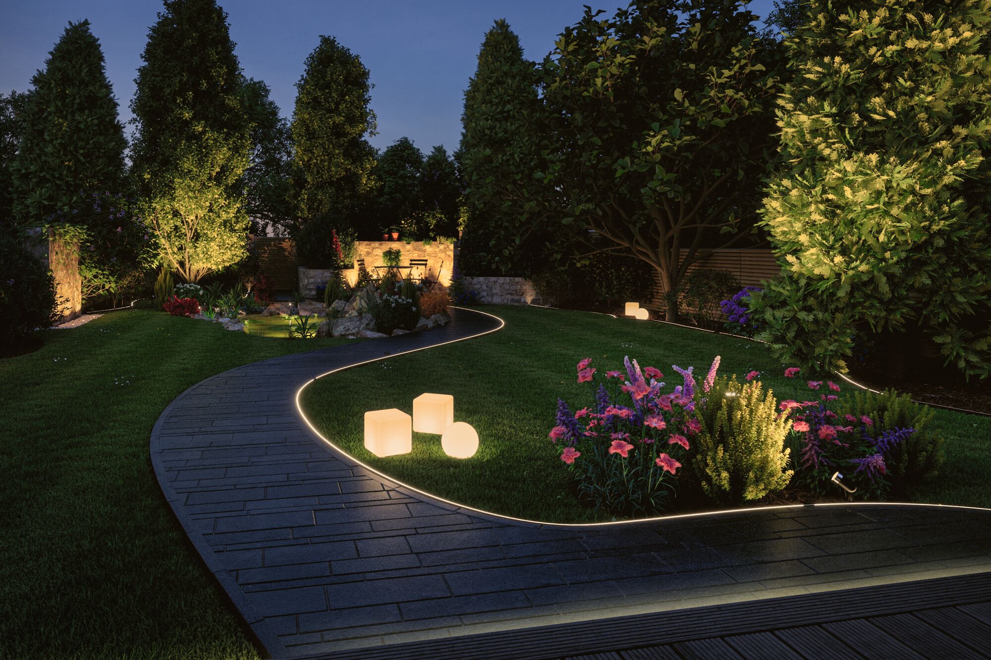 Beleuchteter Gartenweg mit LED-Bodeneinbauleuchten und dekorativen Leuchtwürfeln in Grünanlage bei Nacht