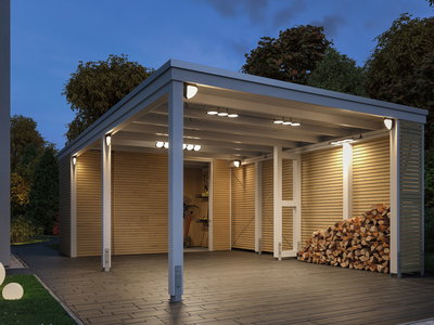 Verlichte witte houten carport met moderne LED-buitenverlichting en gestapeld haardhout in de tuin.
