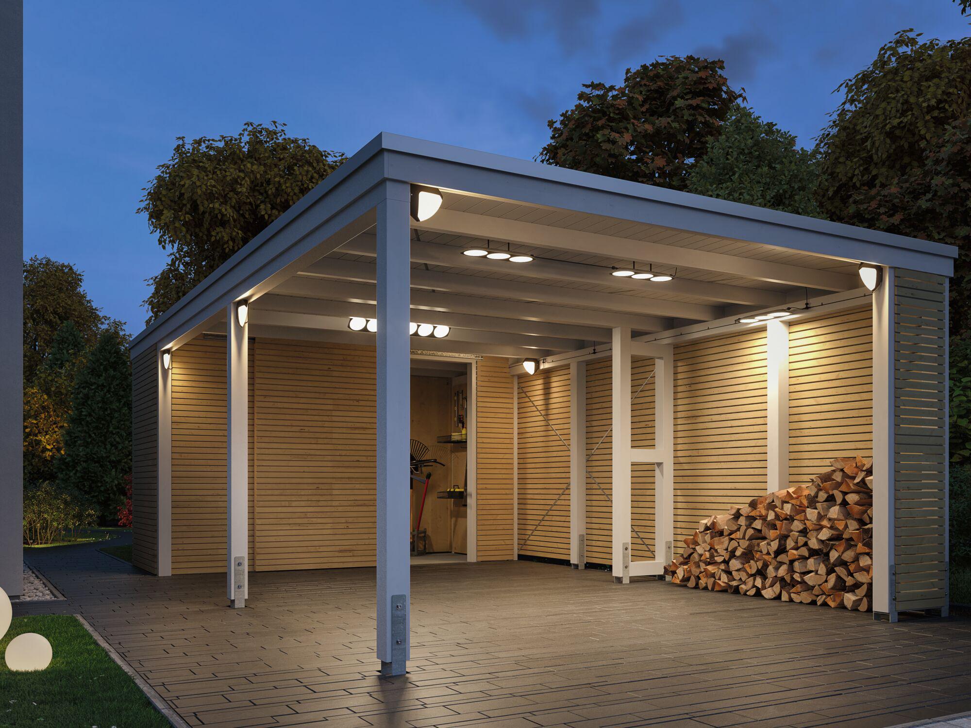 Nowoczesny carport z białą aluminiową konstrukcją i drewnianą okładziną, oświetlony o zmierzchu