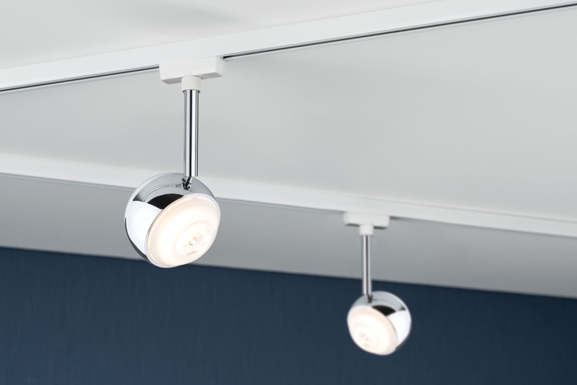 Zwei runde LED-Strahler aus Chrom an weißer Schiene für moderne Innenbeleuchtung