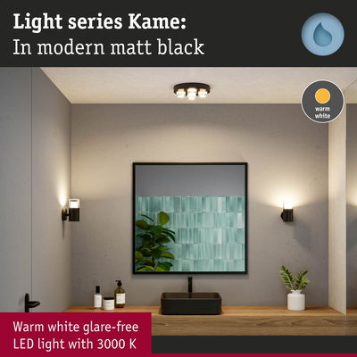 Matt black LED wall and ceiling lights with warm white glow in modern bathroom setting