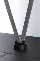 Black round holder with grey fabric strap on dark surface for lighting system accessories
