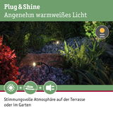 Schwarze LED-Gartenstrahler mit warmweißem Licht auf Kies und Pflanzen für stimmungsvolle Terrasse.
