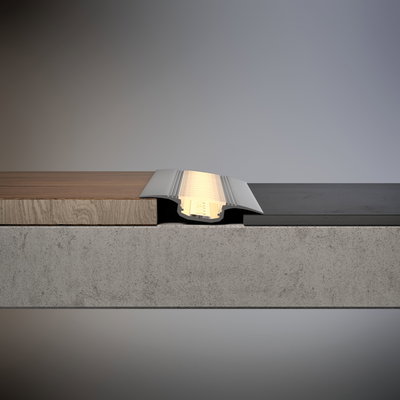 Zilverkleurig aluminium LED-vloerprofiel met warm wit licht tussen hout- en stenen vloer