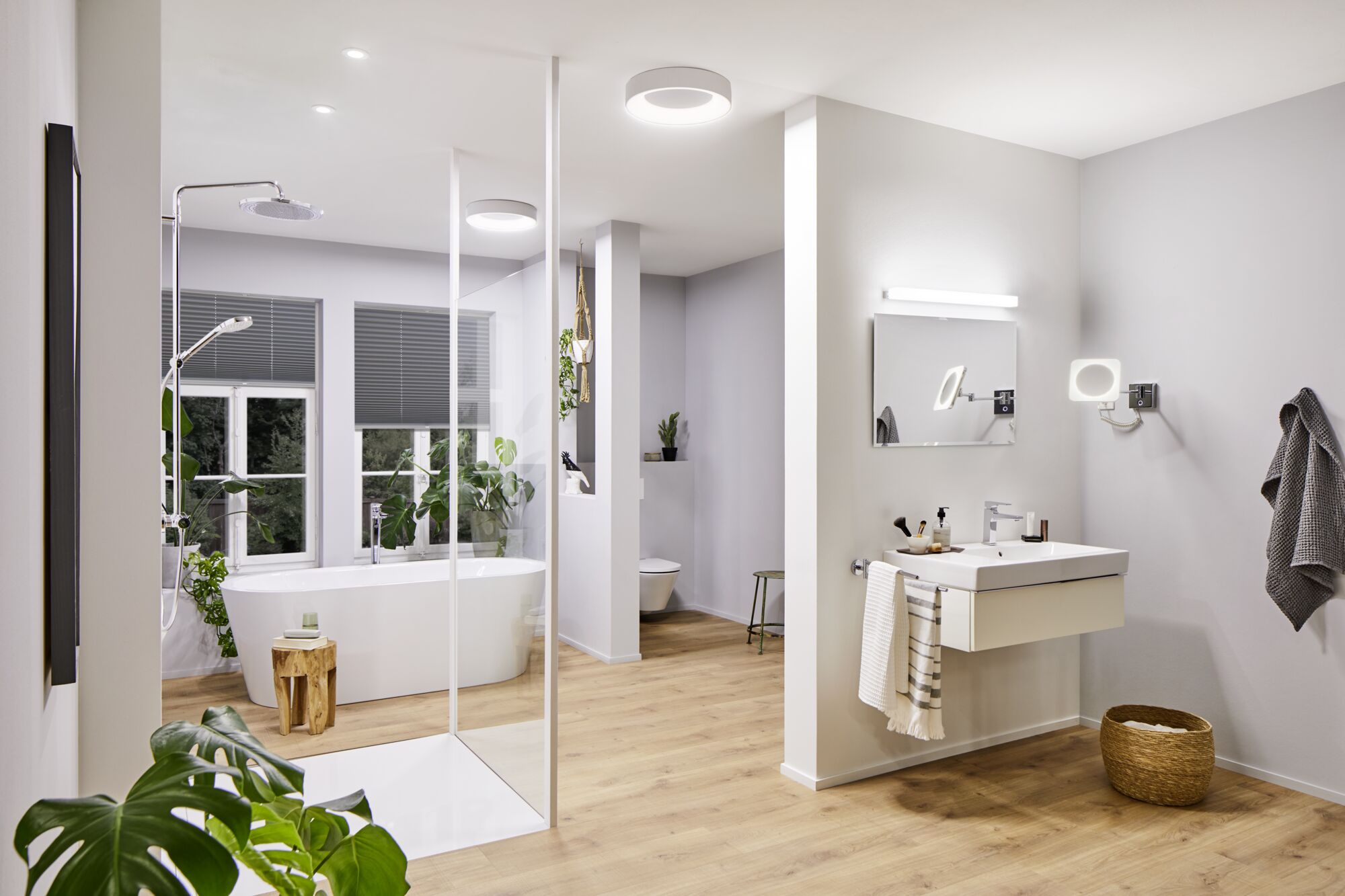 Moderne badkamer met wit bad, houten vloer en ronde witte plafondlampen
