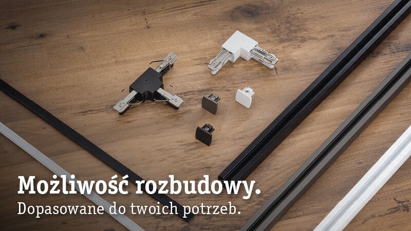 Modułowy system szyn URail z czarnymi i białymi łącznikami na drewnianym tle do elastycznego oświetlenia LED.